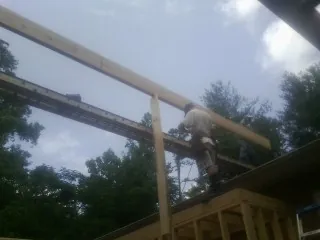 Carpenter setting a ridge beam over a new addition frame — Ice Dam Removal by Roofing Brothers in Morton